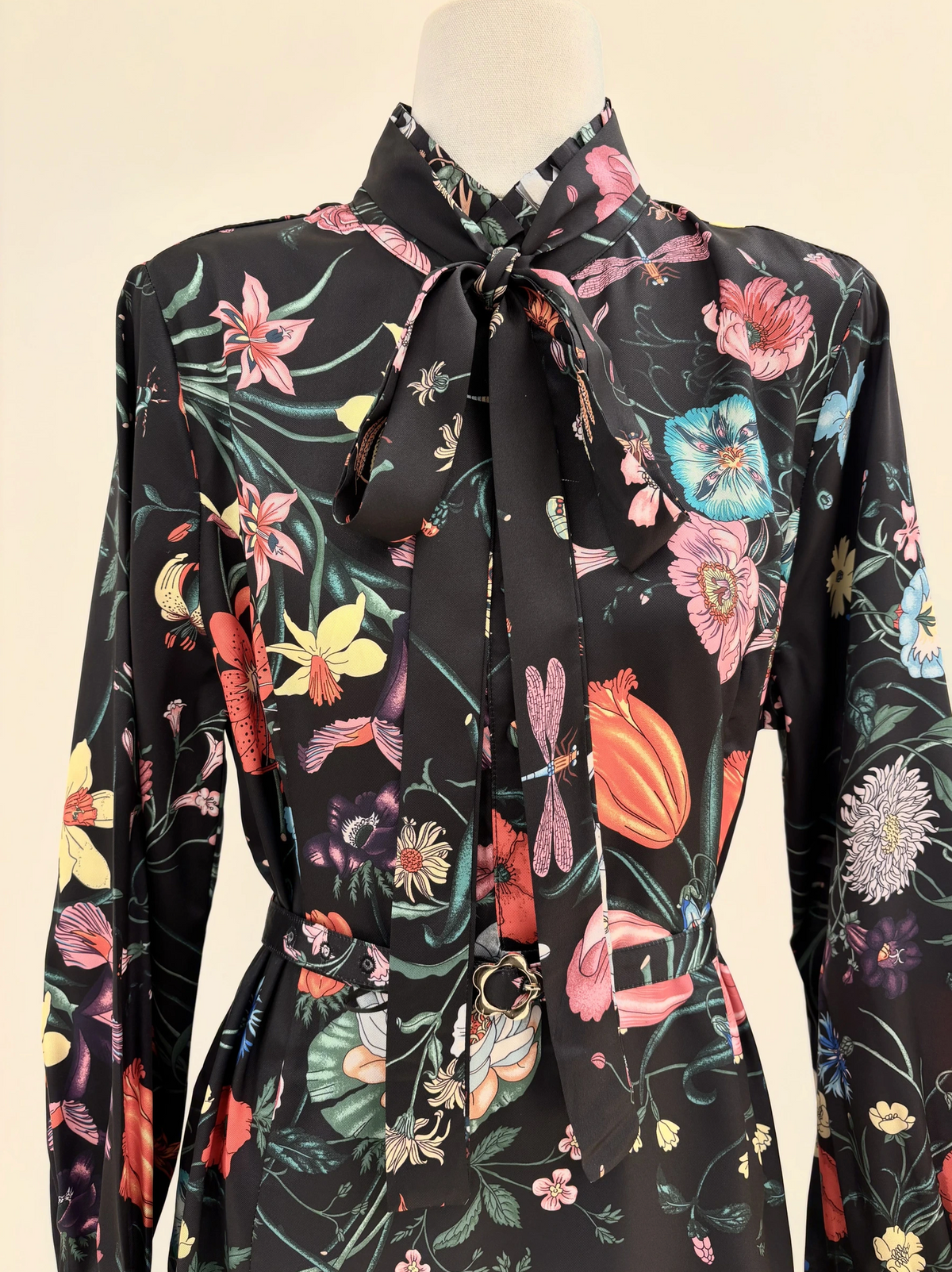 Une robe fluide à imprimé floral, dotée d'un col lavallière et d'une ceinture assortie